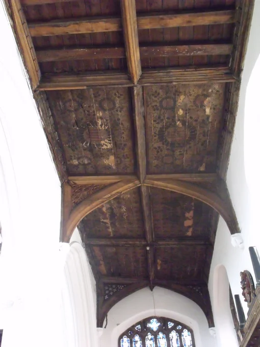  In the south aisle, although most of the fretwork in the spandrels is modern, the 15th century boarded and painted ceiling over the Lady Chapel remains. The western bay has motifs in circles, surrounded by foliage, and the two eastern bays show angels with outstretched wings and inscribed scrolls on a background studded with crowned ‘M’ motifs (for the Virgin Mary). 