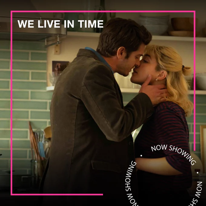 A man and woman kiss in a kitchen. Text - We Live in Time, Now Showing
