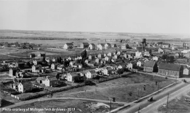 Neighborhood featuring a water tank and houses with large wooden fences