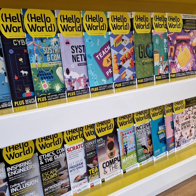 Photo featuring previous copies of Hello World magazine neatly arranged on a book case.