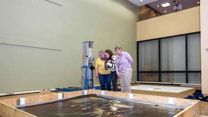 Library staff looking at Robert C. Hinckley’s painting The First Operation Under Ether, on the floor