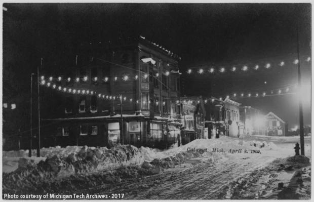 Snow-covered streets surrounded by well-lit buildings