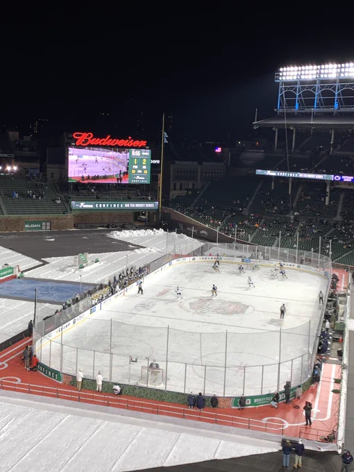 Hockey rink with scoreboard beyond it.