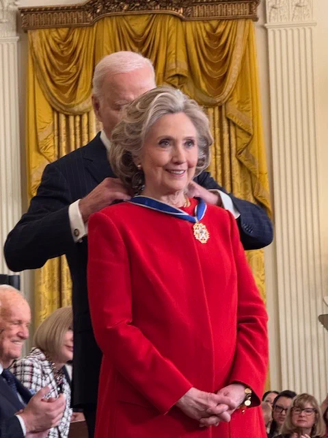 President Biden placing a medal around the neck of Hillary Rodham Clinton