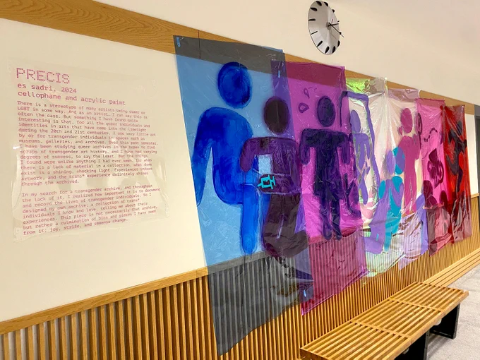 Photo of art installation on blue, purple, clear and red  cellophane showing a series of stick figures 
