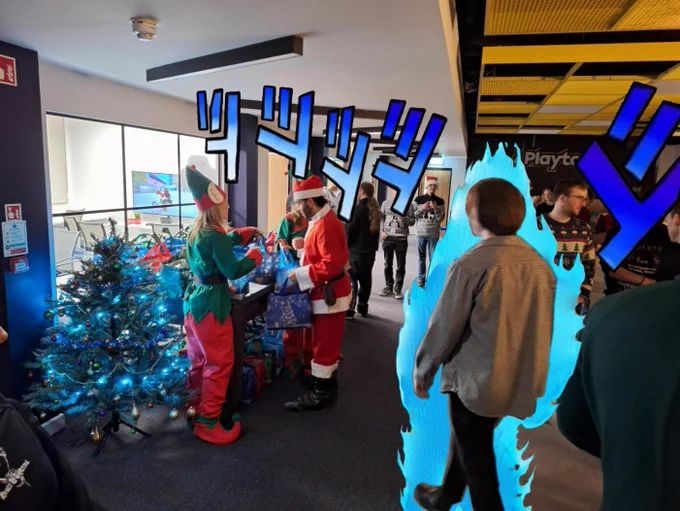 A picture from the Playtonic Christmas party copying the JoJo's meme format "Oh? You're Approaching Me?" with blue flames around Scott as he saunters towards Christmas presents in a room full of people in the background. People dressed as an elf and santa can be seen handing out bags