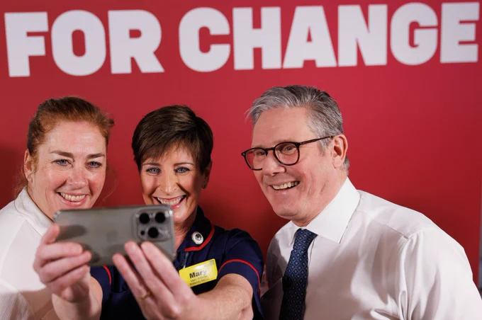 Prime Minister Keir Starmer taking a selfie with two staff members at The South West London Elective Orthopaedic Centre.