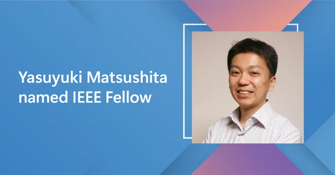 A graphic with a blue and pink geometric background. The text on the left side reads: Yasuyuki Matsushita named IEEE Fellow.