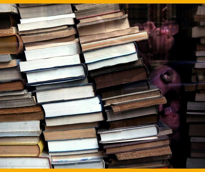 A big stack of books leaning to the left