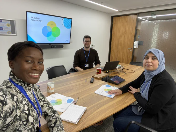 Photo of Theresa, Sonjide, and Tom sat at desk