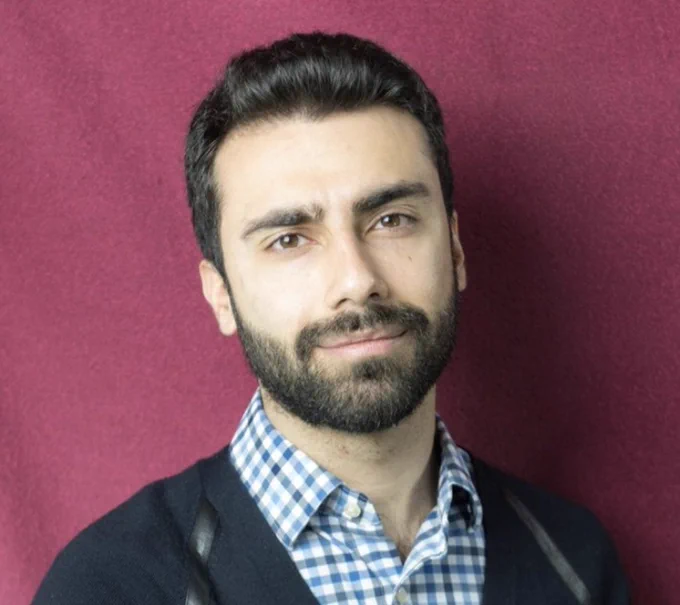 A photo of nonfiction contest winner Mohammad Hakima against a maroon background. 
