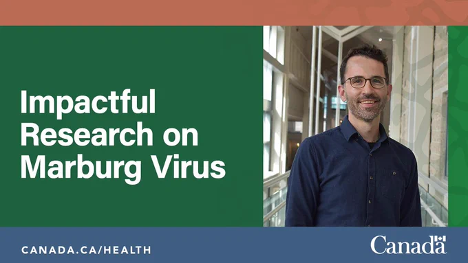 A  man wearing glasses standing in a hallway.  Text reads: Impactful Research on Marburg Virus