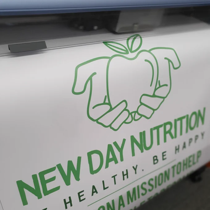 New Day Nutrition banner being printed on a large format printer.
