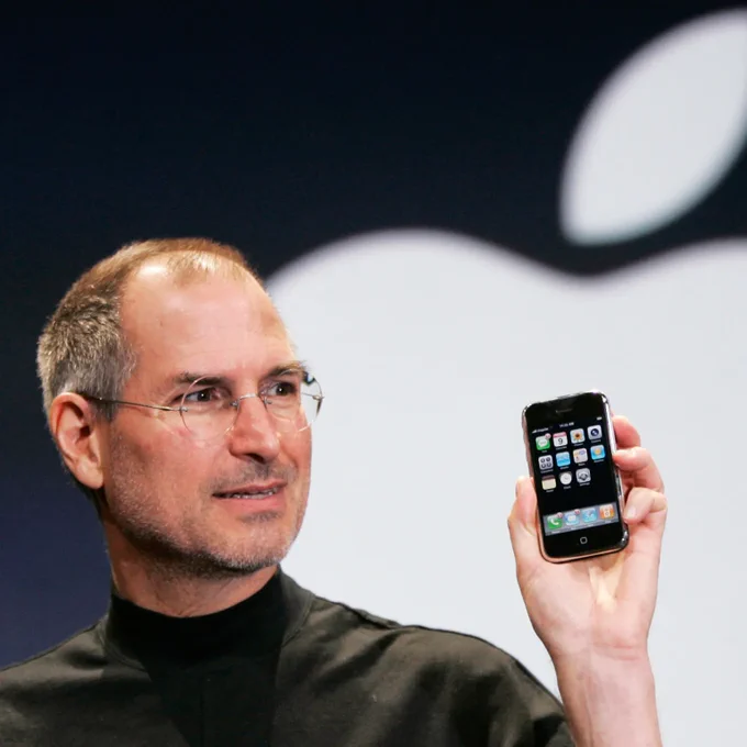 Steve Jobs holding the original iPhone.