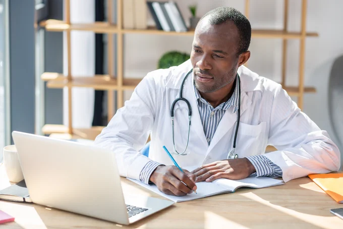 An African American medical student taking notes