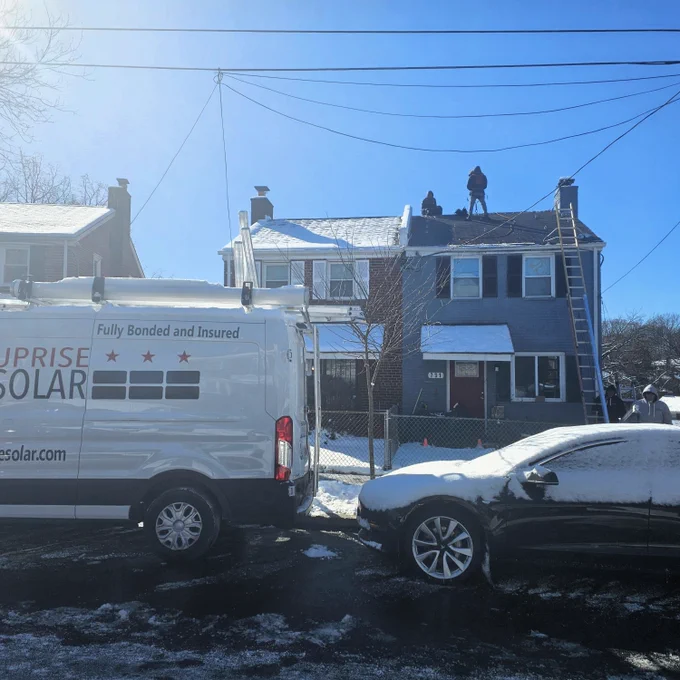 Solar installers working on a solar panel installation in the snow.