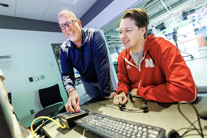 Jamie Wenz (left), technical director in the College of Journalism and Mass Communications, assists Harmon Johnsen, a sophomore sports media and communication and broadcasting major, inside the Don and Lorena Meier Studio. (Jordan Opp/University Communication and Marketing)