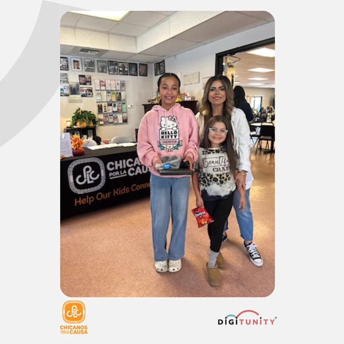 People standing and smiling holding a laptop