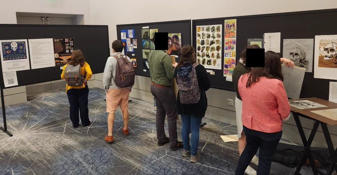 Poster exhibit of art and science communication programming with people examining the works.