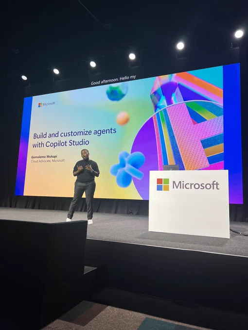 Gomo on stage with slides