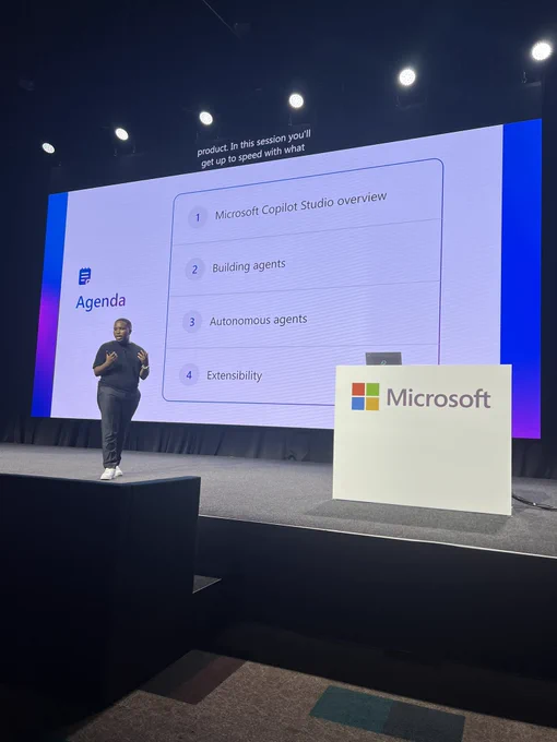 Gomo on stage with agenda slides