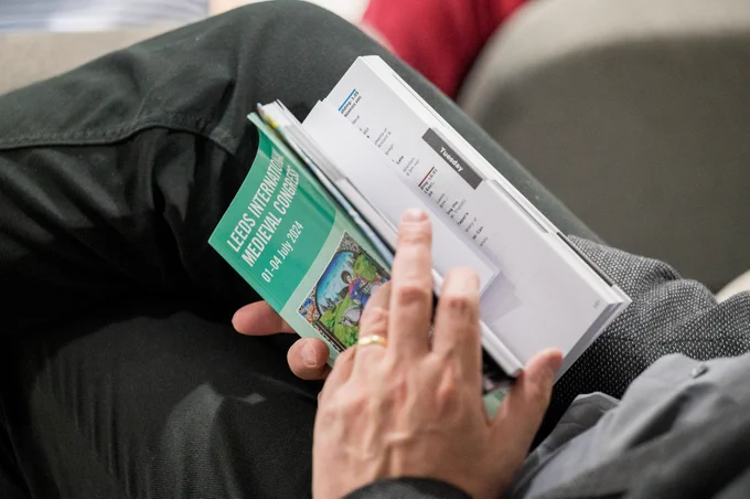 An IMC 2024 Programme held in a delegates hand