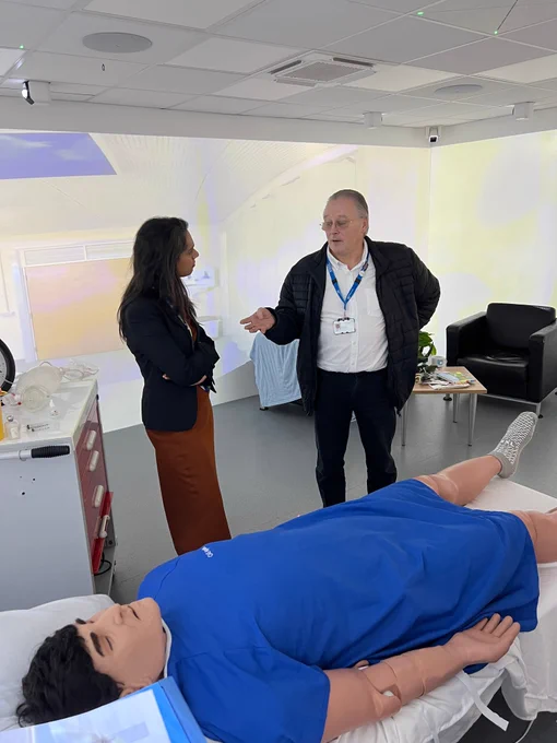 Image shows a governor speaking with a member of the simulation team inside the immersive simulation suite.