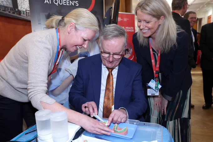Image shows Health Minister Mike Nesbitt being taught how to clean plaque from teeth by our Dentistry colleagues.
