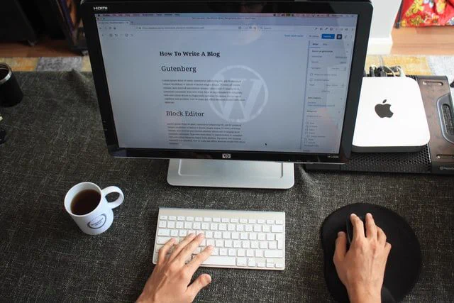A user's hands sitting on a desktop computer keyboard.
