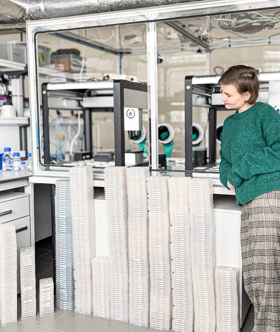 Female scientist next to stacked lab plates