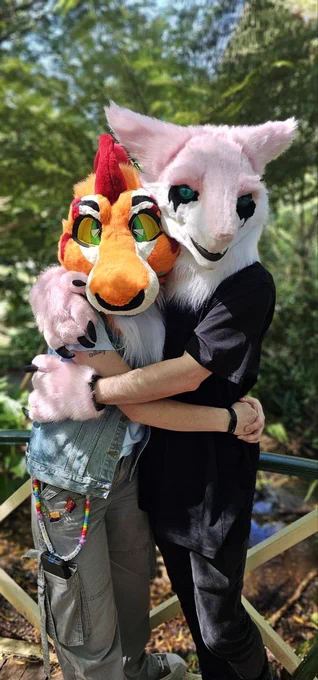 Two fursuiters hugging while posing for a photo