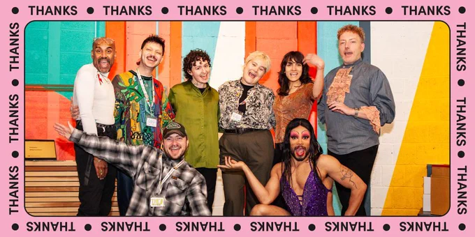 A frame of Mosaic’s brand colour pink, with text reading ‘Thanks’ repeated along it. The photo shows a group picture of Mosaic’s staff, mentors and alumni all posing and looking happy, celebrating at the showcase.
