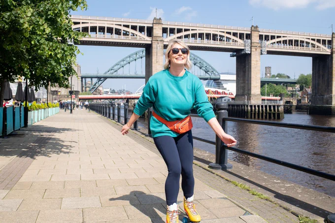 A woman roller skating along Newcastle Quayside with the High Level Bridge, Tyne Bridge and Swing Bridge in the background.
Credit: NGI/ Angela Carrington