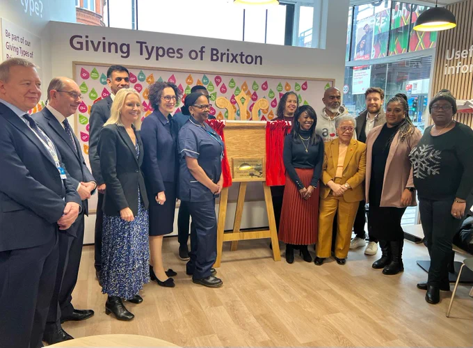 A group of smartly dressed people pose inside Brixton Blood Donor Centre as the centre is unveiled. They include Bell, other politicians, community leaders and clinicians.