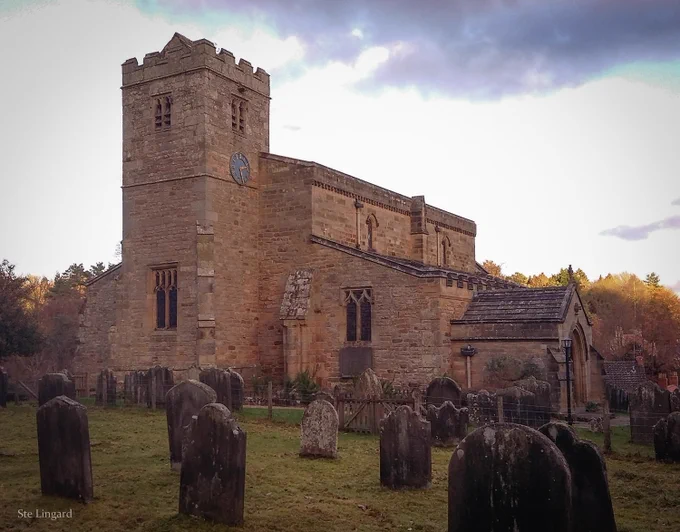 An old church building set in a graveyard, with a gloomy sky beyond. 
