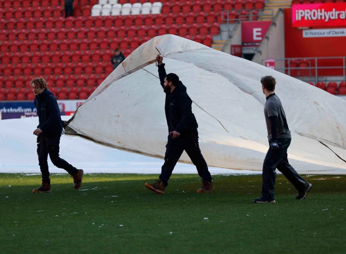 The grounds staff take off the covers and prepare the pitch at AESSEAL New York Stadium.