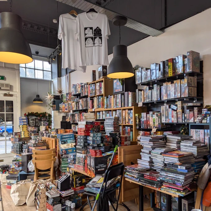 The Edinburgh board game shop Ancient Robot Games during the cleaning process. There are board games and RPGs on piles on the floor.
