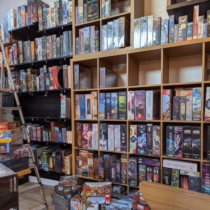 The Edinburgh board game shop Ancient Robot Games during the cleaning process. Board games are organised alphabetically on the shelves.