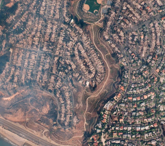 Aerial imagery of a neighborhood along the coast showing half of the houses burned
