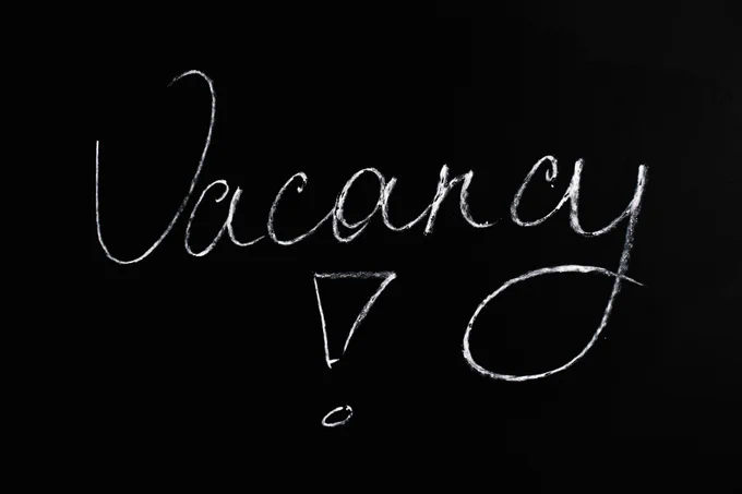 The word "Vacancy!" written in white chalk like writing on a black background