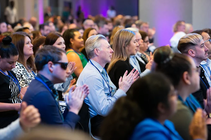 Audience clapping at an event. 