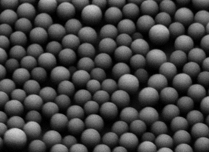 A black and white photo of self-assembling spheres