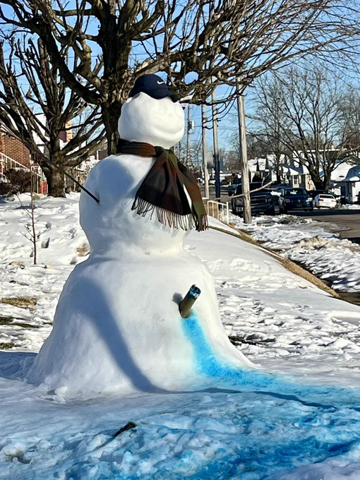 Image of large snowman with a fake penis and blue liquid sprayed on the white snow.