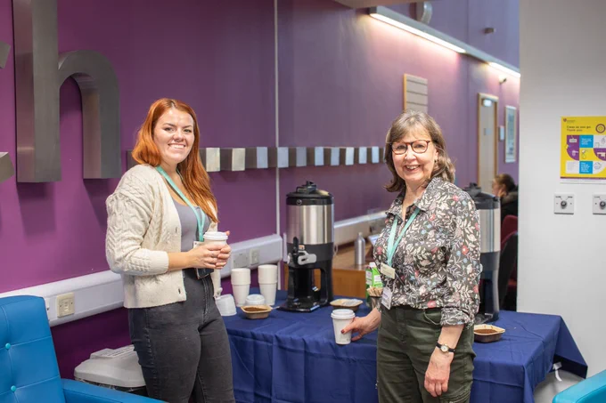 Friendly Bill Bryson Library staff standing in front of a coffee cart.