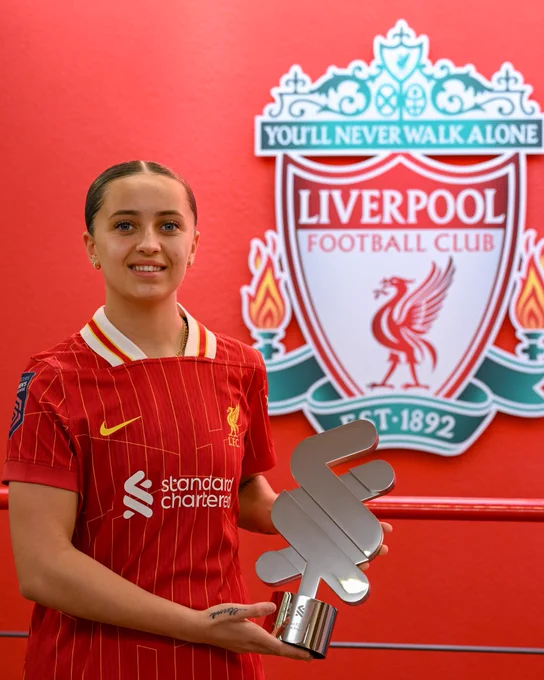 Mia Enderby holding the Standard Chartered Player of the Month trophy. 