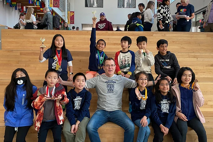 Jonathan Roberts sits with his daughter's elementary school math club, which he mentors.