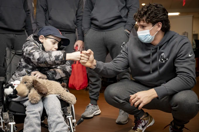 Roman Anthony fist bumps a young patient in a wheelchair at The Jimmy Fund.