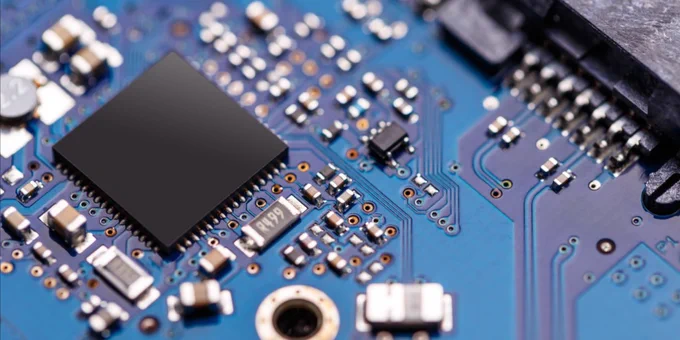 Close-up image of a circuit board featuring various electronic components including microchips, capacitors, and connectors.