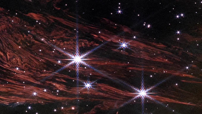 These shimmering cosmic curtains show interstellar gas and dust that has been heated by the flashbulb explosion of a long-ago supernova. The gas then glows infrared light in what is known as a thermal light echo. As the supernova illumination travels through space at the speed of light, the echo appears to expand. NASA’s James Webb Space Telescope observed this light echo in the vicinity of the supernova remnant Cassiopeia A. NASA, ESA, CSA, STScI, J. Jencson (Caltech/IPAC)