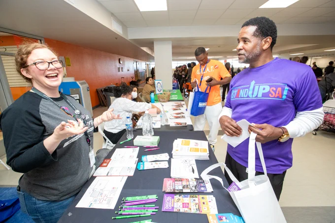 Two people at a table with various stationery.